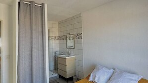 A bedroom with a bed, a bathroom with a sink and mirror, and a shower curtain. - Apartment with harbor and sea view 4PPII26 (LE BARCARES)