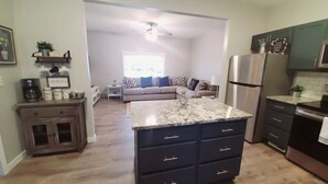 A modern kitchen with dark cabinetry, a granite countertop, and stainless steel appliances. - Dog Friendly|Fenced|Full Kitchen|Firepit (Alpena)