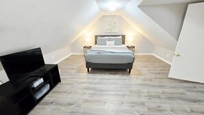 A bedroom with a bed, bedside lamps, a TV, and a ceiling light. - Dog Friendly|Fenced|Full Kitchen|Firepit (Alpena)