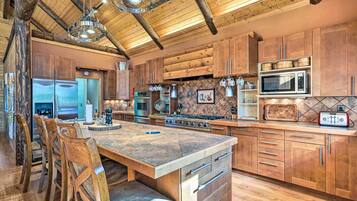 A spacious kitchen with wooden cabinets, a large island, and modern appliances.