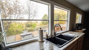 A kitchen with a large window, a sink, and a countertop. - Secluded Country Retreat- Hot Tub & Fire Pit-3BR minutes to Z-Plex and Downtown  (McKinney)