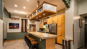 A kitchen with a central island, wooden cabinets, and a stainless steel refrigerator.
