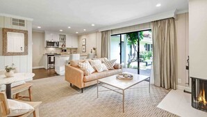 A modern living room with a beige sofa, a coffee table, and a fireplace. - Poolside Retreat | Patio | 10 Min to DT (Napa)