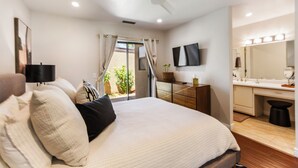 Un dormitorio con cama, mesita de noche y vistas al exterior.