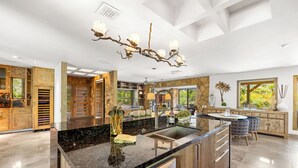 Una cocina moderna con una isla central, encimeras de granito y lavavajillas integrado.