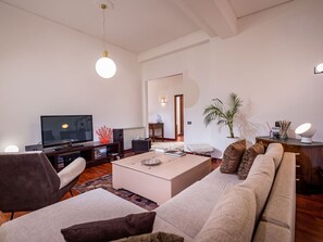Un soggiorno moderno con divano, tavolino, televisore e oggetti decorativi.