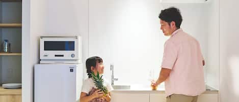 A modern kitchen with a built-in microwave, a refrigerator, and a sink.