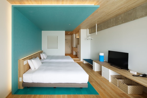 A modern hotel room with two beds, a TV, and a desk with a computer. - BEB5 Okinawa Seragaki by Hoshino Resorts (Onna)