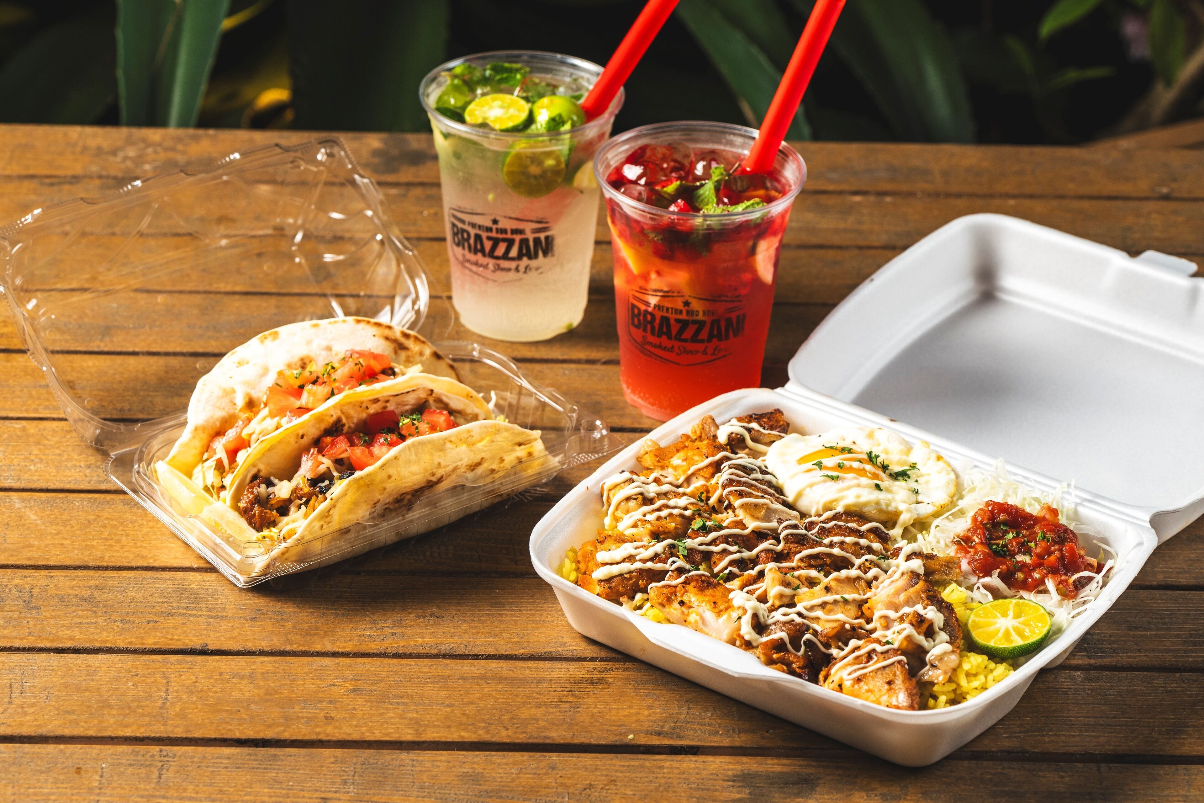 Comida con tacos, arroz y una bebida sobre una mesa de madera.