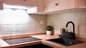 A modern kitchen with a built-in sink, wooden countertop, and a potted plant. - Holidays2Malaga Union Studio Renovated - High Speed WiFi (Málaga)