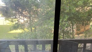 Une terrasse en bois avec une table en verre et deux chaises.