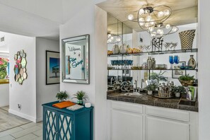 Enjoy a stylish kitchen with sleek cabinetry, granite countertop, and a large mirror.
