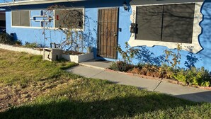 A two-story house with a blue exterior, a front door, and a garage door. - 2 Bedroom Home 20 Minutes From Everything! (North Las Vegas)