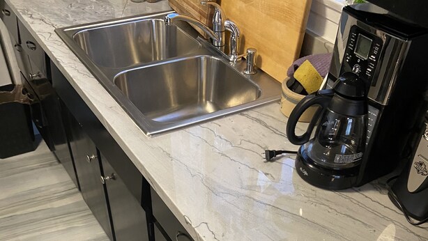 A kitchen with a marble countertop, stainless steel sink, and a coffee maker. - 2 Bedroom Home 20 Minutes From Everything! (North Las Vegas)