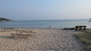Une plage avec des tables de pique-nique et des bancs.