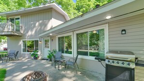 Une terrasse avec un barbecue, du mobilier d’extérieur et un foyer.