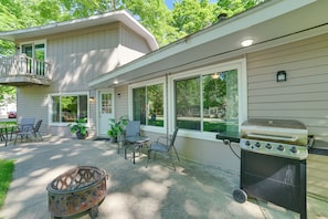 Une terrasse avec un barbecue, du mobilier d’extérieur et un foyer.
