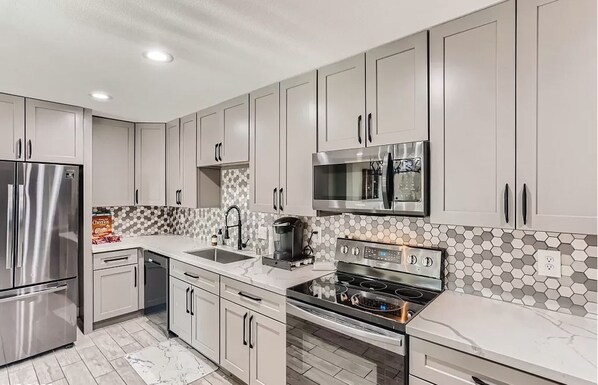 Enjoy cooking in this well-equipped kitchen with a refrigerator, microwave, oven, and sink.
