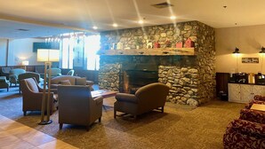 Eine gemütliche Lobby mit Kamin aus Stein, bequemen Sitzgelegenheiten und einer Kaffeebar.