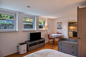 Un dormitorio con cama, televisor, escritorio y silla.