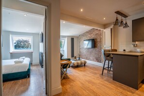 Un intérieur moderne comprenant une cuisine, un coin repas et une chambre avec une grande fenêtre.