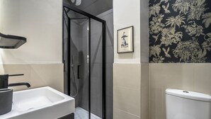 A bathroom with a glass-enclosed shower, a white sink, and a toilet. - A premium stay that sleeps 2 guests  in 1 bedroom (York)
