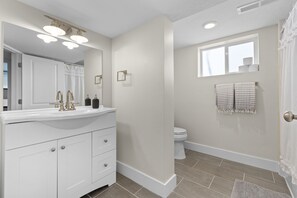 A modern bathroom with a white vanity, a large mirror, and a shower area. - 5BR Mountainside Home w/ Views - Near SLC, Park City & Lagoon (Bountiful)