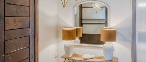 A bathroom with a wooden vanity, two wall-mounted lamps, a mirror with a star-shaped light, and a decorative star above the mirror.