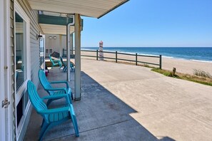 A beachside porch with a concrete floor, a railing, and a view of the ocean.