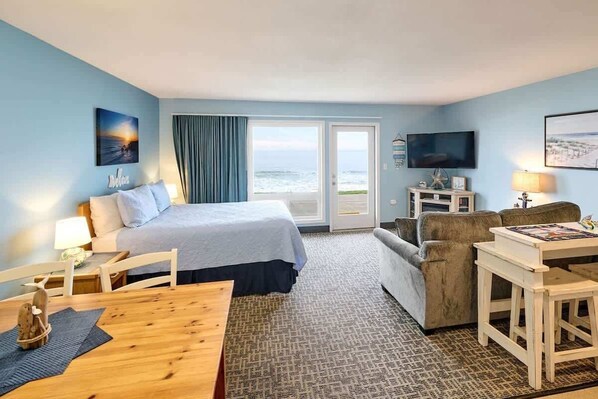 Une chambre d’hôtel avec un lit, une télévision, un bureau et une vue sur l’océan.