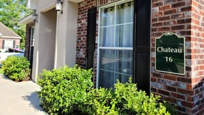 A brick building with a large window and a sign reading "Chateau 16". - Chateau 16, spacious townhouse in Tickfaw, LA (Tickfaw)