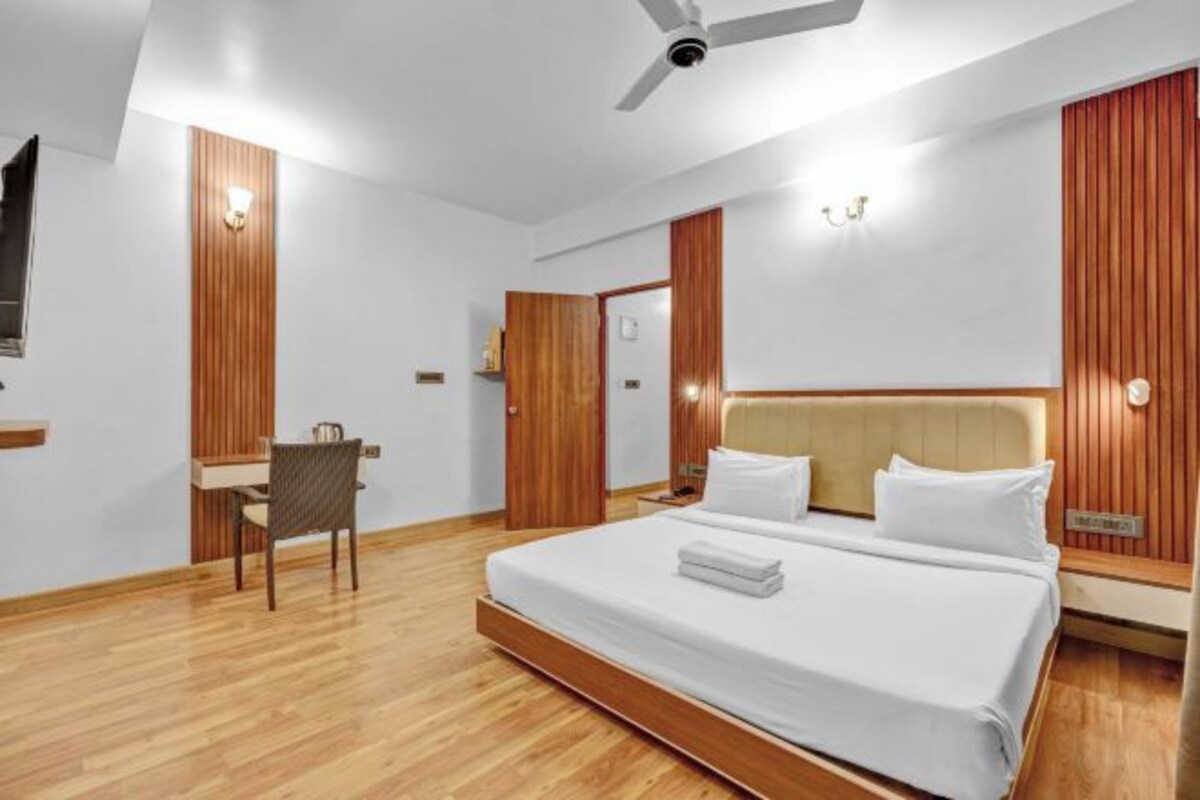 Una habitación de hotel con una cama grande, un escritorio y una silla.