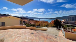 A terrace with stone flooring, overlooking a coastal town with buildings and a clear blue sky. - Casetta Letizia in Portoferraio (Portoferraio)