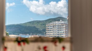 A view of a building with multiple floors and balconies, surrounded by greenery and a body of water. - Casetta Letizia in Portoferraio (Portoferraio)