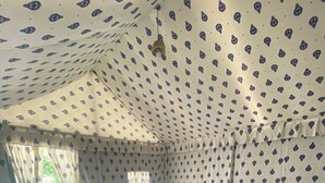 Een gezellige kamer met een bed, een tafeltje en een raam.