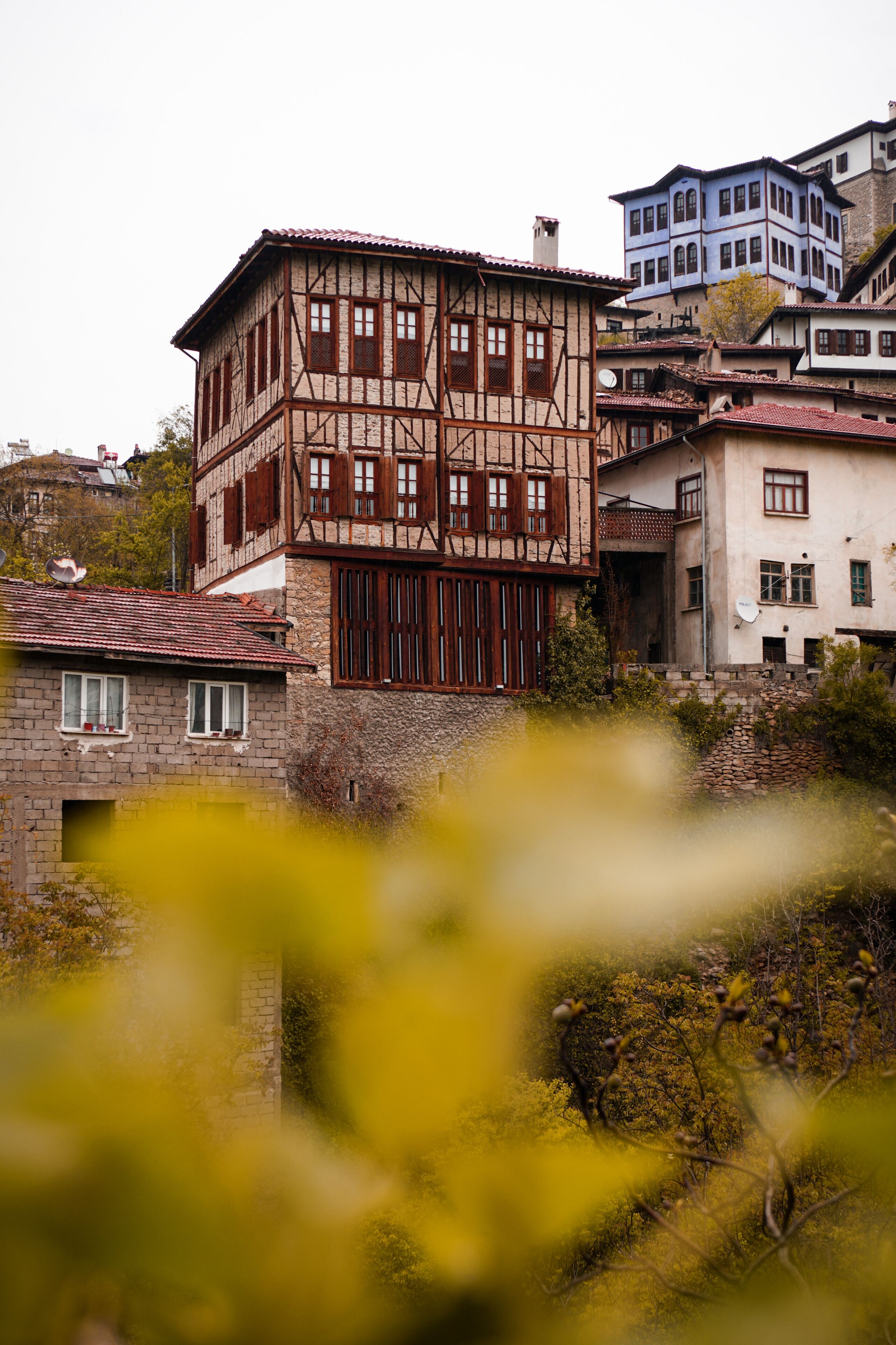 A traditional building with a timber-framed structure, a red-tiled roof, and a satellite dish.