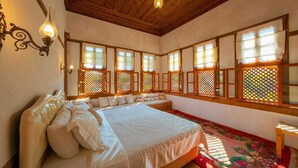 Ein traditionelles japanisches Schlafzimmer mit einem großen Bett, Holzbalken und verschiebbaren Shoji-Bildschirmen.