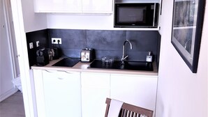 A compact kitchen with a microwave, toaster, and sink. - Lovely studio in private residence + parking. Beach, port and shops on foot (Cavalaire-sur-Mer)
