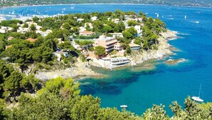 A coastal town with buildings surrounded by trees and a clear blue sea. - Lovely studio in private residence + parking. Beach, port and shops on foot (Cavalaire-sur-Mer)