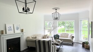 A living room with a fireplace, two sofas, a striped armchair, and a coffee table. - Grounds of Robertson. Stylish and Exclusive. (Robertson)