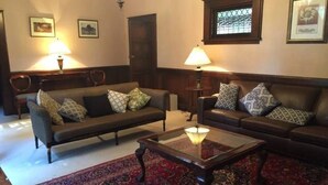 Ein Wohnzimmer mit zwei Sofas, einem Couchtisch und einem gemusterten Teppich.