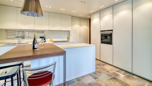 A modern kitchen with a central island, white cabinetry, and a built-in oven. - Villa Bella Elena Private Swimming Pool (Vergiate)