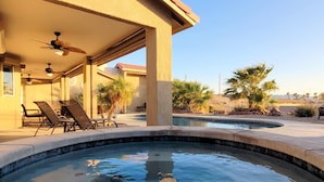 A pool area with lounge chairs and a ceiling fan. - "Hacienda Hangout"~ 5⭐RETREAT ~ PETS OK 🐾  VIEWS - POOL - SPA - BORDERS BLM  (Lake Havasu City)