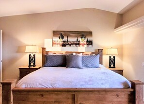 Cozy retreat with a large bed, bedside tables, and a wall-mounted artwork.