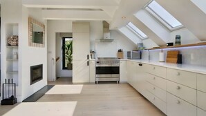 A modern kitchen with a built-in oven, a microwave, and a large window. - Little Hayloft by Bloom stays -  charming barn with hot tub (Canterbury)