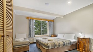 A hotel room with a large bed, a smaller bed, a nightstand, a wardrobe, and a window with curtains. - Providence Park (Providence Portal)