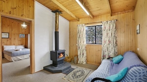 A cozy room with a bed, a sofa, a fireplace, and a window with curtains. - Providence Park (Providence Portal)