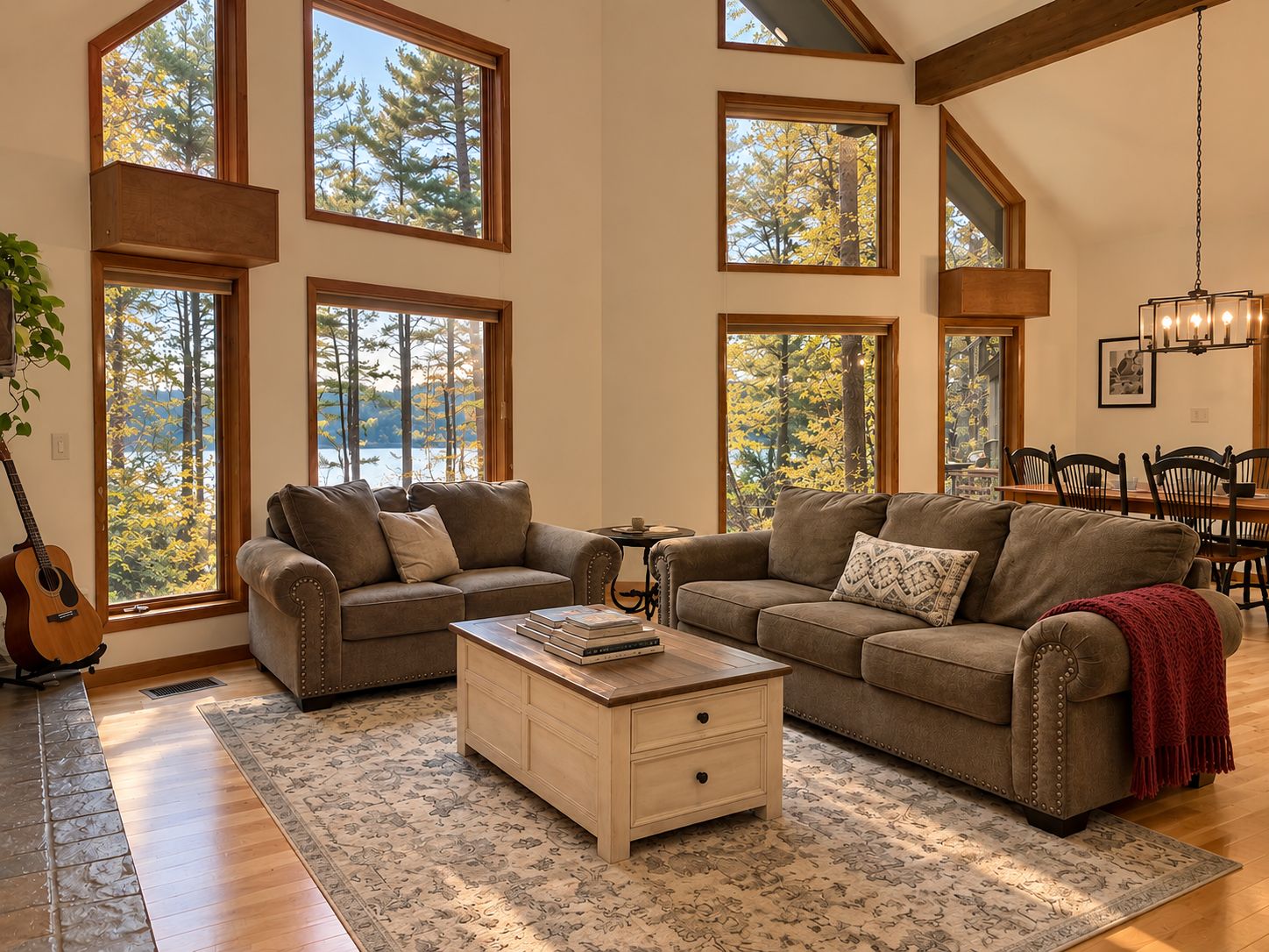 Main living room with soaring windows overlooking the lake and wooded grounds.