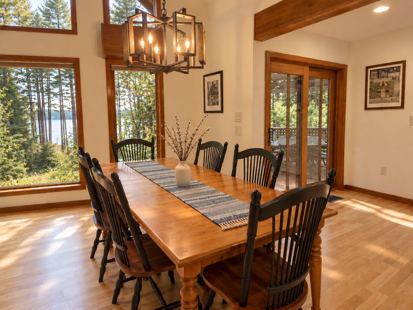A dining room with a wooden table, chairs, and a chandelier.