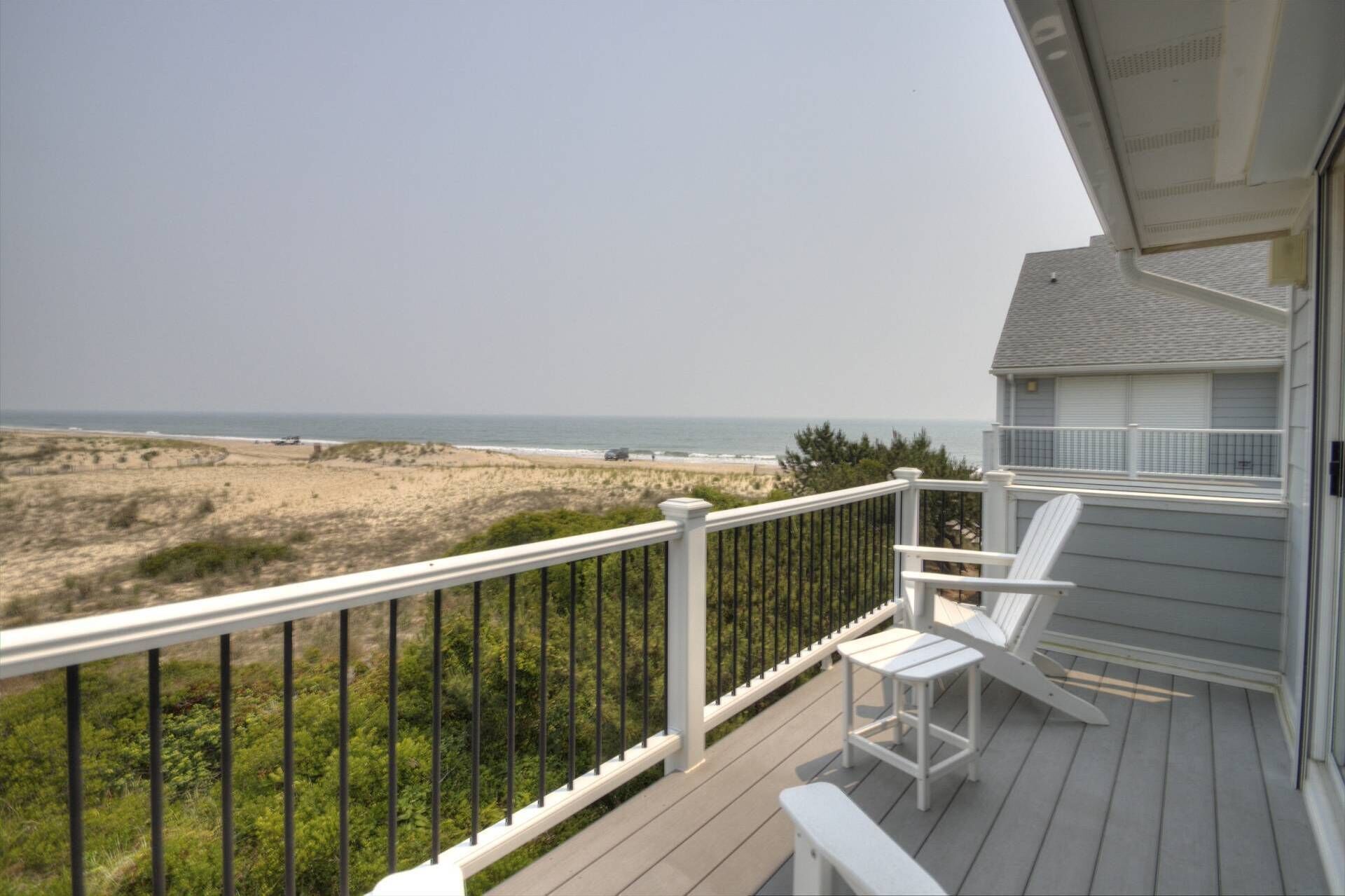 Ein Balkon mit Blick auf Strand und Meer.